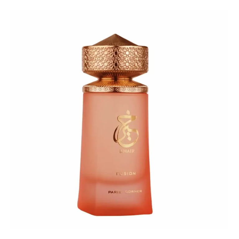 Coral-colored perfume bottle with ornate gold cap and decorative emblem on a white background